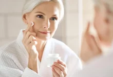 امرأة تفحص بشرتها في عيادة طب التجميل