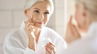 امرأة تفحص بشرتها في عيادة طب التجميل