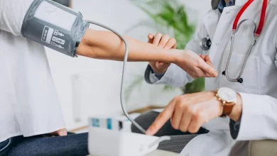دكتور في عيادة الطب العام يقيس ضغط مريض