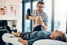 أخصائي الترويض الطبي يقدم العلاج الفيزيائي لمريض في مركز العلاج الطبيعي