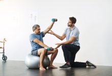 أخصائي العلاج الفيزيائي يقدم العلاج الطبيعي لأجل إعادة التأهيل الحركي في مركز الترويض الطبي